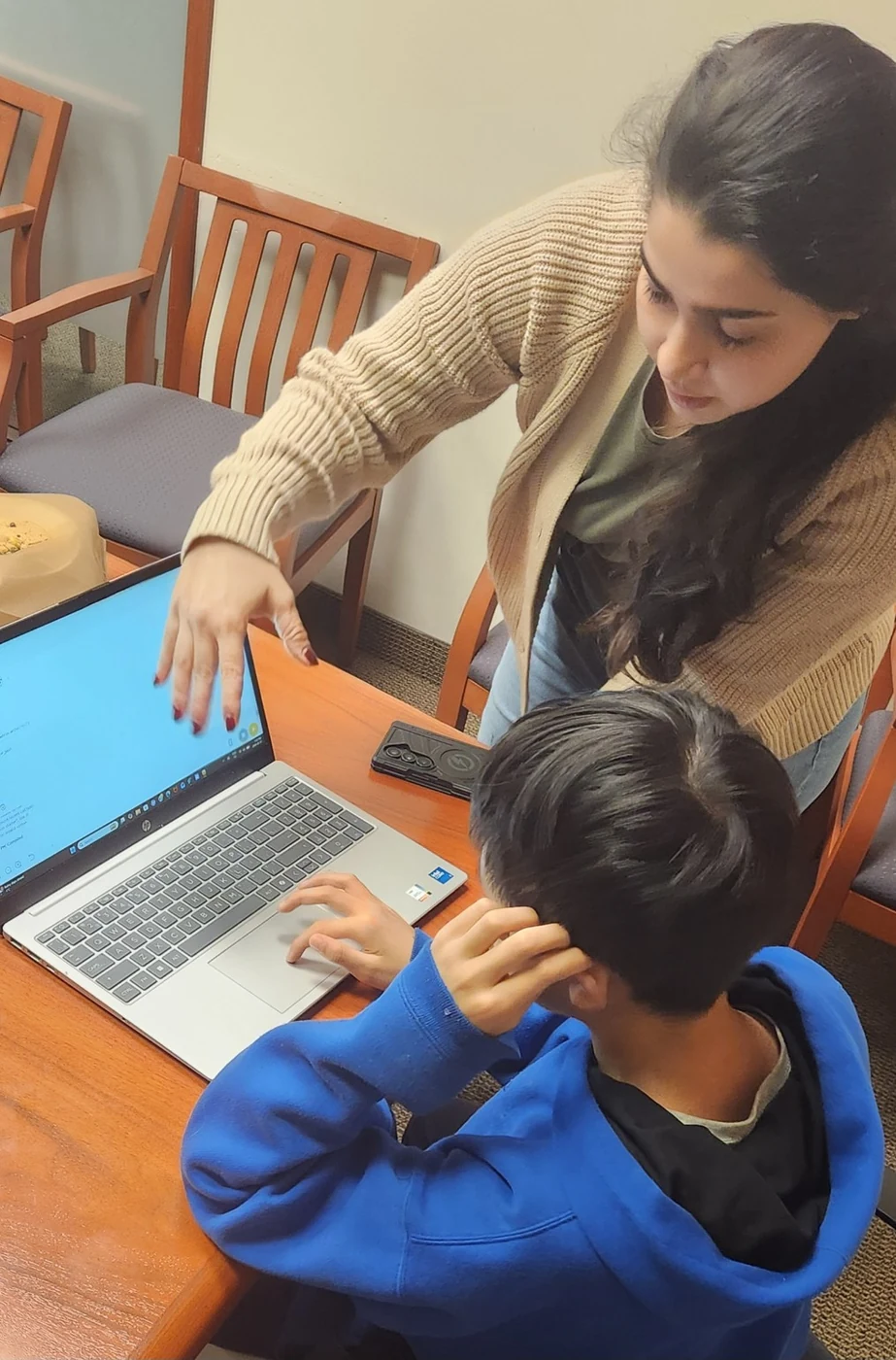 Coach working individually with a student at a laptop